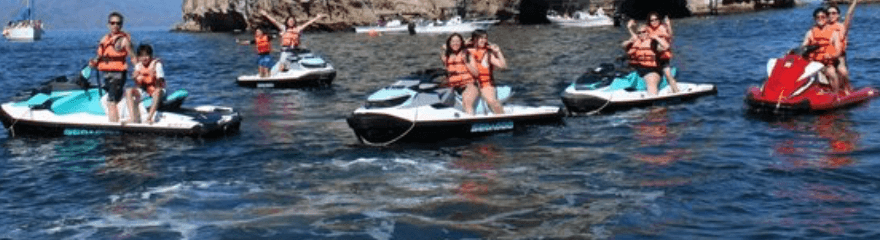 Grupo en jet skis con chalecos salvavidas sobre agua azul